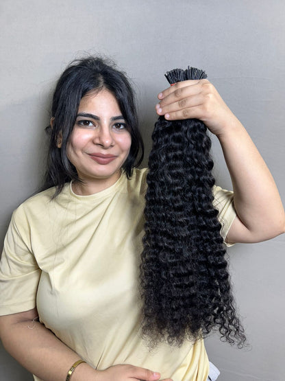 Curly human hair I-tip extension bundle with dense ringlet texture, dark black