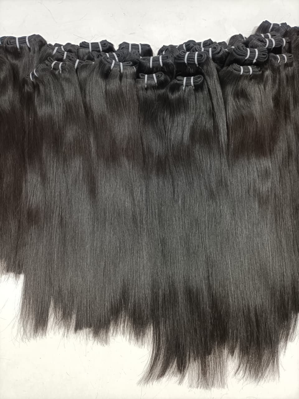 Multiple rows of dark straight hair weft bundles, neatly bound at the top