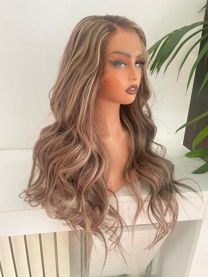 Ash blonde and brown mix lace front wig made from 100% raw human hair by Gaurash Beauty Supply, styled with soft waves.