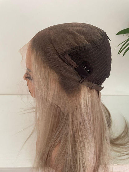 Blonde HD lace front wig with raw human hair on an adjustable cap, styled with soft waves for a natural look.